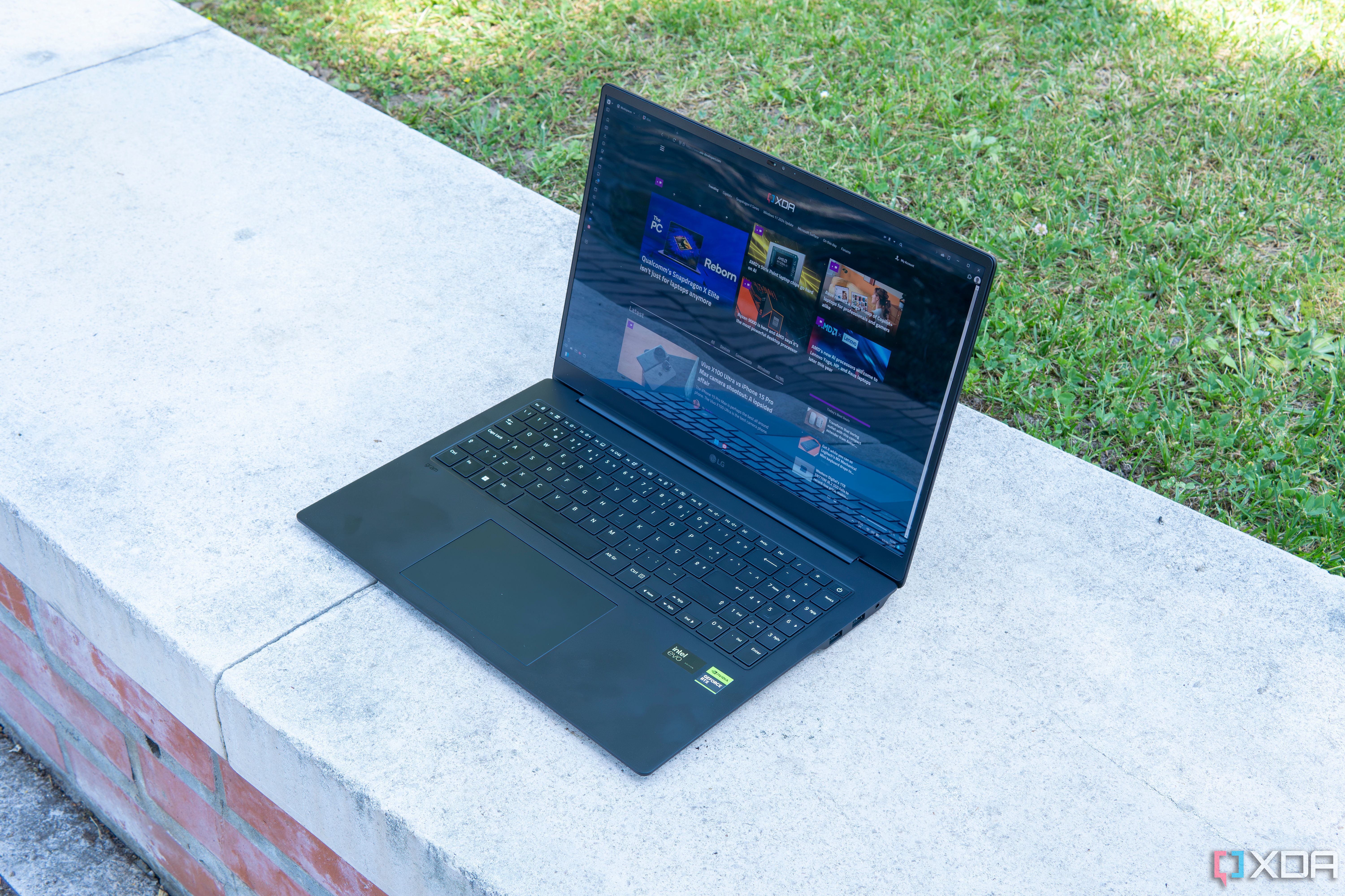 Angled view of the LG Gram Pro on a stone slab with grass in the background