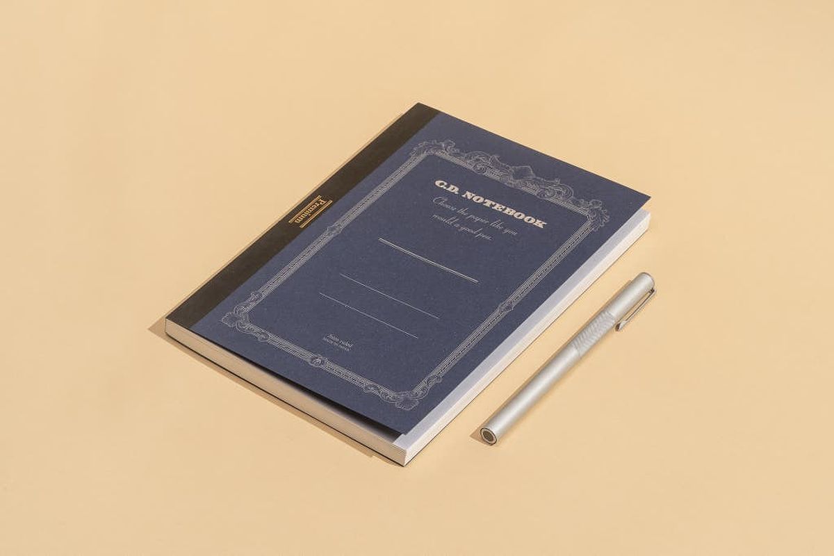 Apica Premium C.D. Notebook next to a pen